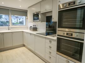 A kitchen with cabinets and appliances at White Sails in Y Felinheli