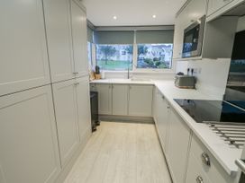 A kitchen with cabinets, sink, and appliances at White Sails Y Felinheli