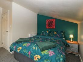 A bedroom with a bed, nightstand, and towels at Top Lodge in Llanvair-Discoed near Penhow