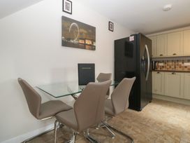 A kitchen with a dining table and refrigerator at Top Lodge in Llanvair-Discoed near Penhow