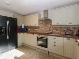 A kitchen with appliances and cabinets at Top Lodge in Llanvair-Discoed near Penhow