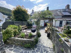 A garden with a barbecue and seating area at Swn Yr Afon in Abergynolwyn near Tywyn
