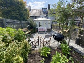 A garden with chairs and a grill at Swn Yr Afon in Abergynolwyn near Tywyn
