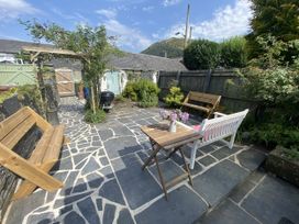 A garden with a table and benches at Swn Yr Afon in Abergynolwyn near Tywyn
