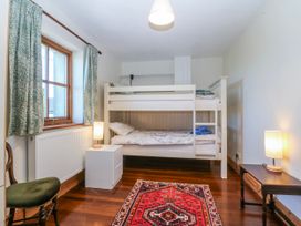 A bedroom with a bunk bed and a rug at Bronfa in Tregarth