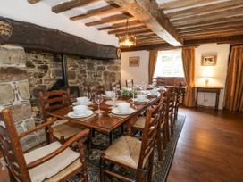 A dining room with a long wooden table set with white dishes and glasses at Pentre Hall in Bronygarth near Chirk