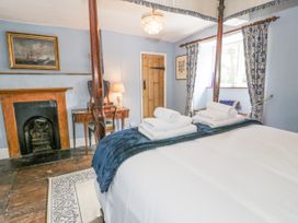A bedroom with a four-poster bed folded towels on the bed a wooden door and a fireplace at Pentre Hall in Bronygarth near Chirk