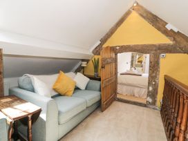 A small sitting area with a light blue sofa and pillows near a wooden door leading to a bedroom at Pentre Hall Bronygarth near Chirk
