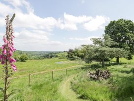 A grassy field with a fenced path and trees under a cloudy sky at Pentre Hall in Bronygarth near Chirk