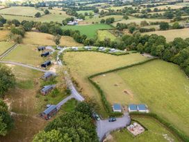 An aerial view of a landscape with cabins and fields at The Otter in Nantmel near Rhayader