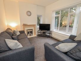 A living room with a sofa and television at 1 Eamont Park in Penrith