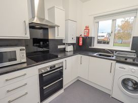 A kitchen with appliances including a microwave, oven, and washing machine at 1 Eamont Park Penrith