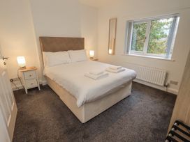 A bedroom with a bed and nightstand at 1 Eamont Park in Penrith