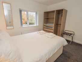 A bedroom with a bed and wardrobe at 1 Eamont Park in Penrith
