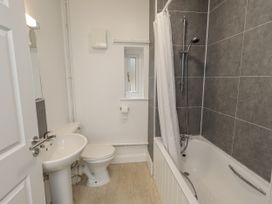 A bathroom with a bath tub, shower, toilet, and sink at 1 Eamont Park, Penrith
