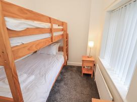 A bedroom with a bunk bed and single bed at 1 Eamont Park in Penrith
