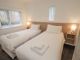 A bedroom with two single beds and a window at 1 Eamont Park Penrith