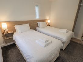 A bedroom with twin beds and a lamp at 1 Eamont Park Penrith