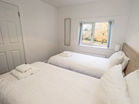 A bedroom with two beds and a window at 1 Eamont Park Penrith