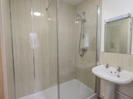 A bathroom with a shower and wash basin at 1 Eamont Park in Penrith