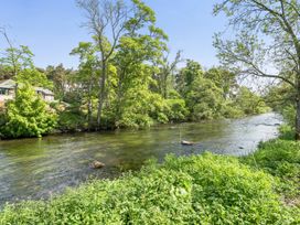 A river with trees and a building in the background at Jubilee Three Bedroom House Pet Free Penrith