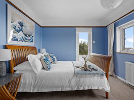 A bedroom with a bed and art on the wall at 7 Duporth Bay in St. Austell