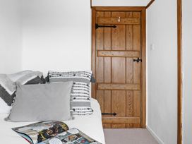 A bedroom with a bed and wooden door at 7 Duporth Bay in St. Austell