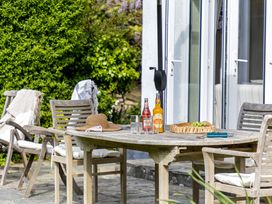 An outdoor patio with a table and chairs at 7 Duporth Bay in St. Austell