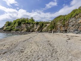 A beach with sand and cliffs at 7 Duporth Bay in St. Austell