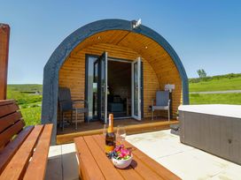 An outdoor area with a wooden pod structure and seating at Beech in Ulverston