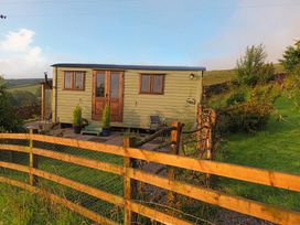 A shepherd's hut with surrounding garden area at The Herdsman Luxury Shepherds Hut in Barnoldswick