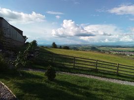 An outdoor view of a landscape with a fence and grass at The Herdsman Luxury Shepherds Hut Barnoldswick