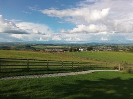 An outdoor area with a grassy field and distant hills at The Herdsman Luxury Shepherds Hut Barnoldswick