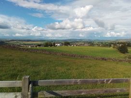 A landscape view with grass field and hills at The Herdsman Luxury Shepherds Hut in Barnoldswick
