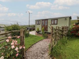 A garden with a shepherd's hut and flowers at The Herdsman Luxury Shepherds Hut Barnoldswick