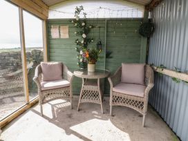 A seating area with two chairs and a table at The Herdsman Luxury Shepherds Hut in Barnoldswick