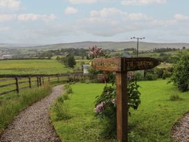A signpost and gravel path in a garden area at The Herdsman Luxury Shepherds Hut in Barnoldswick