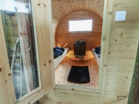 A sauna interior with wooden benches and a heater at The Herdsman Luxury Shepherds Hut in Barnoldswick