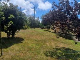 A garden with trees and bushes at Ty Gwenyn in Rhydwyn