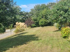 A garden with grass and trees at Ty Gwenyn in Rhydwyn
