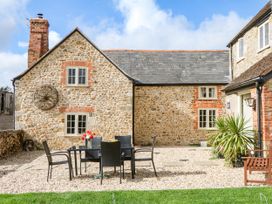 An outdoor dining area with a table and chairs at The Abbey Grange near Charmouth