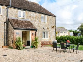 A house with a patio area and seating at The Abbey Grange near Charmouth