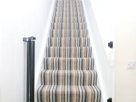 A staircase with striped carpet at The Abbey Grange near Charmouth