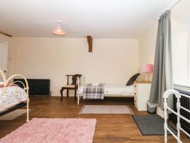 A bedroom with two beds and a chair at The Abbey Grange near Charmouth