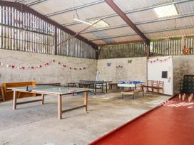 A recreation room with tables and ping pong table at The Abbey Grange near Charmouth