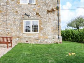 A garden with a stone wall and a bench at The Abbey Grange near Charmouth