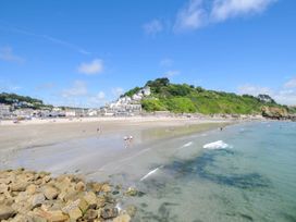 A beach with water and people near buildings at The Abbey Grange near Charmouth