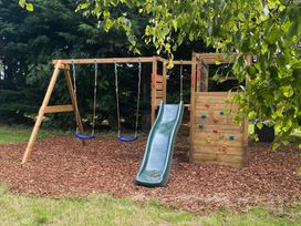 A playground with swings and a slide at The Hollies near Carlisle