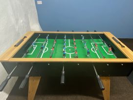 A foosball table with red and blue figurines in a game room at The Hollies in Thurstonfield near Carlisle