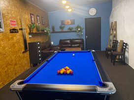 A game room with a pool table and a sofa at The Hollies in Thurstonfield near Carlisle